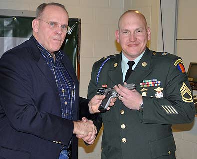 FORT BENNING, Ga. – Col. (RET) Robert I. Hoidahl, Jr, president, Military Marksmanship Association, presents a .45-cal. pistol to Sgt. 1st Class James Henderson, U.S. Army Marksmanship Unit Jan. 29 at Pool Indoor Range. Henderson was named the 2009 MMA Soldier of the Year. (Photo by Michael Molinaro, USAMU PAO)