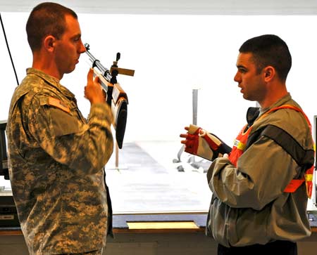 FORT BENNING, Ga.--Spc. Joe Hein, U.S. Army Marksmanship Unit, instructs Staff Sgt. Kenny Griffith, Warrior Transition Brigade, Fort Hood, Texas, on proper positioning with an air rifle Mar. 30 at Pool Indoor Range. Griffith was among 16 Wounded Warriors who came to Fort Benning to get rifle and pistol training from the experts of the USAMU in preparation of the Warrior Games, an inaugural event being held May 10-14 at the Olympic Training Center. (Photo by Michael Molinaro, USAMU PAO)