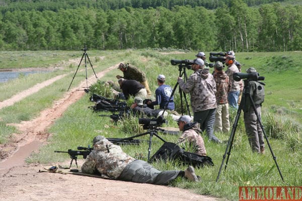 Shooter stretching bullets off a dam bank across a lake to 1000 yards. Note the number spotting scopes involved in the shoot.