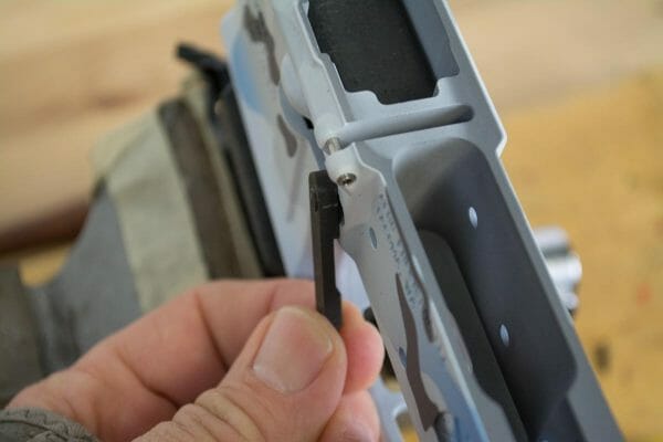 If you push the magazine release button into the receiver you can rotate the catch lever to tighten the two parts.