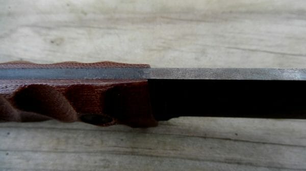 A set of sculpted Micarta grips adorn the tang and are finished in a medium brown color. 