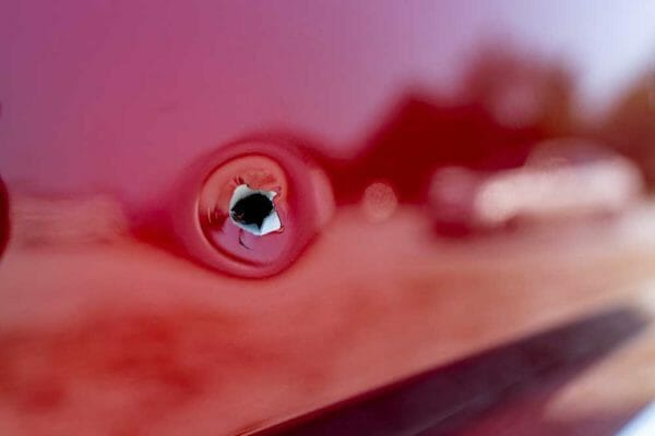 Bullet hole metal car iStock-Brian Koellish 1339937918