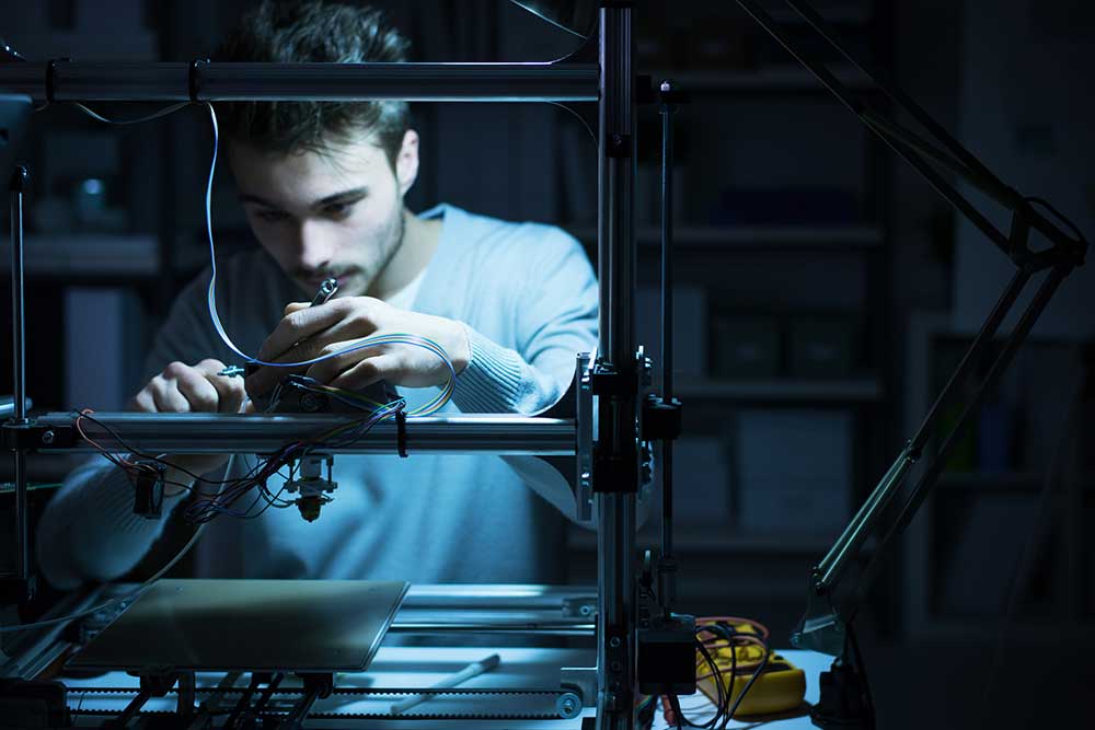 Young engineer working on a 3D printer 3d guns ghost iStock-demaerre 586694292