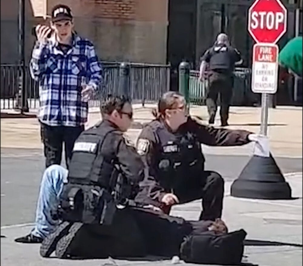 Tanner Cook of the “Classified Goons” YouTube Channel lays on the ground while receiving first aid from law enforcement after being shot in the stomach by a Door Dash driver who feared for his life.